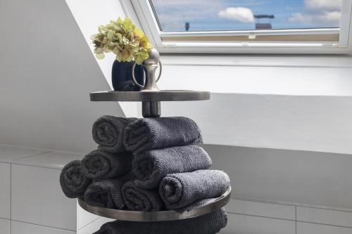 a pile of towels in a bathroom next to a window at Dhh Im Norden Hamburgs Am Moor in Henstedt-Ulzburg