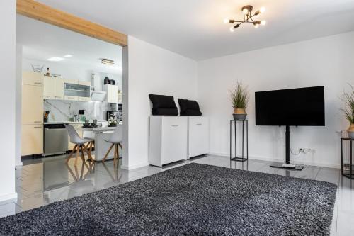 a living room with a tv and a kitchen at Dhh Im Norden Hamburgs Am Moor in Henstedt-Ulzburg