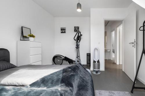 a white bedroom with a bed and a dresser at Dhh Im Norden Hamburgs Am Moor in Henstedt-Ulzburg
