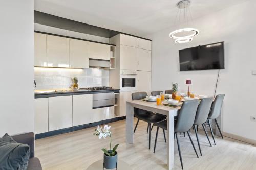 a kitchen and dining room with a table and chairs at NAT Apartments in Koper