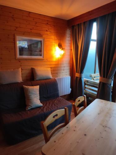 un salon avec un canapé et une table dans l'établissement Les Villages du Bachat à Chamrousse 1700 - Arolles E11 Classé 3 étoiles, à Chamrousse