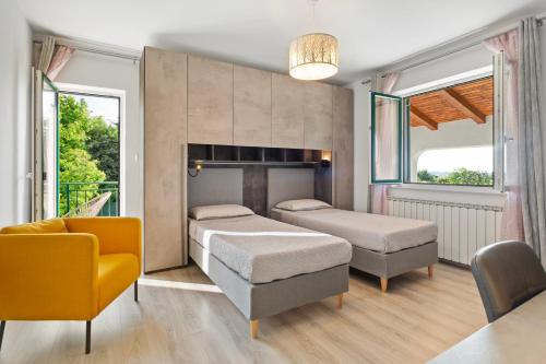 a bedroom with two beds and a couch and windows at NAT Apartments in Koper