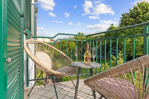 a patio with two chairs and a table with a bottle of wine at NAT Apartments in Koper