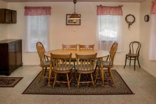 a dining room with a wooden table and chairs at Maple Hide A Way in Hammondsport