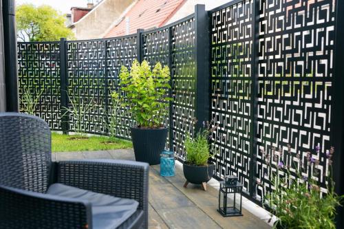 a black fence with potted plants on a patio at Haven Apart Nowa Sól in Nowa Sól