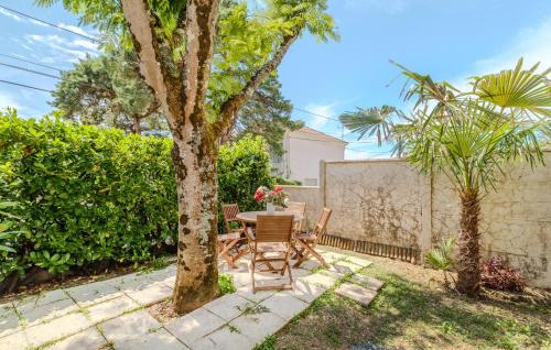 Un patio con una mesa y sillas debajo de un árbol. en Cozy Apartment In Saint-Palais-Sur-Mer, en Saint-Palais-sur-Mer