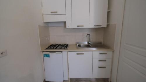 a small kitchen with white cabinets and a sink at Agriturismo il Vignaletto in Martina Franca