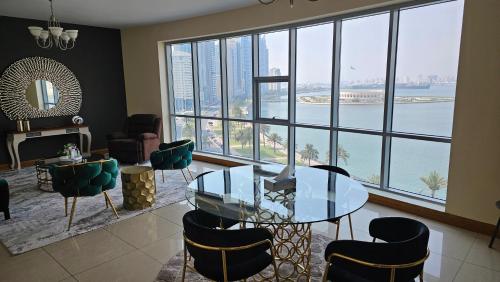 a room with a glass table and chairs and a large window at Luxury Private Rooms in Sharjah