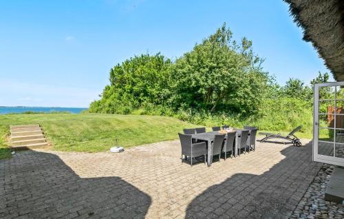 un patio con mesa, sillas y un campo en 4 Bedroom Amazing Home In Assens, en Assens