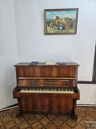 a piano sitting in a room with a painting on the wall at Freestyle Hostel Baku in Baku