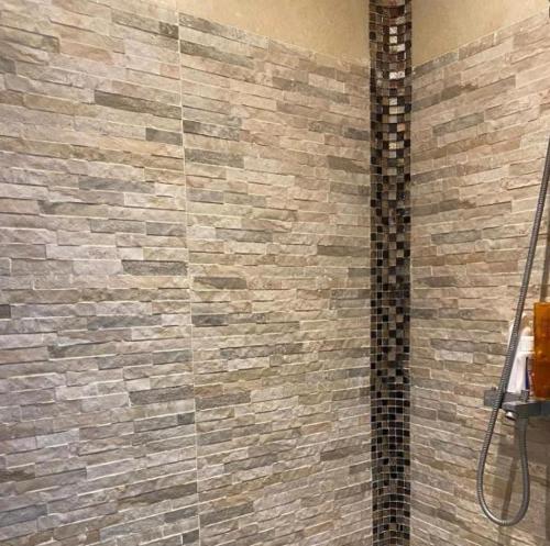 La salle de bains est pourvue d'une douche et d'un mur en briques. dans l'établissement T2 Spacieux Marseille centre ville, à Marseille