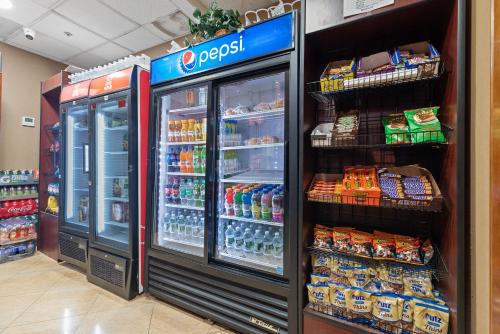 a grocery store aisle with an open refrigerator at Hotel Executive Suites in Carteret
