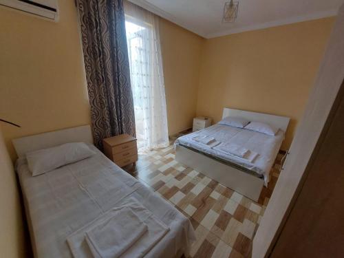 a small bedroom with two beds and a window at Hotel NUCA in Gonio