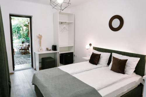 1 dormitorio con 1 cama con sábanas blancas y almohadas marrones en MOLDOs Haus, en Sibiu