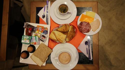 a table with breakfast foods and a cup of coffee at Parc Hotel in Paris