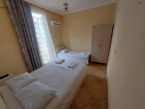 a small room with a bed and a window at Hotel NUCA in Gonio