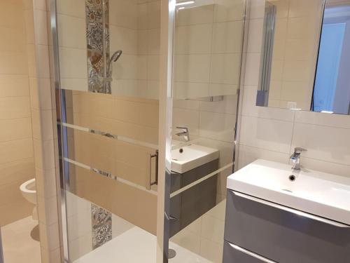 une salle de bain blanche avec un lavabo et une douche dans l'établissement Appartement 4 personnes dans domaine privé, calme, plage, à Bormes-les-Mimosas