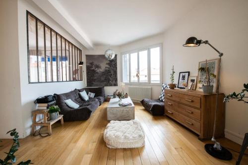 un salon avec un canapé et une table dans l'établissement Atelier St Didier-Spacieux avec grand balcon-Saône, à Lyon