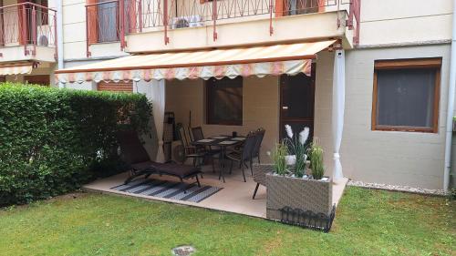 a patio with a table and chairs on a house at Sunny Apartman in Siófok