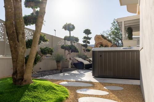 a garden with a tree and a patio at Residence AleDen in Vieste