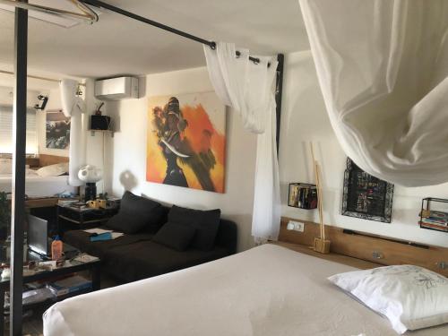 une chambre avec un lit et un canapé dans l'établissement Votre espace glamour EN COHABITATION avec nous deux dans notre appartement du village naturiste, au Cap d'Agde