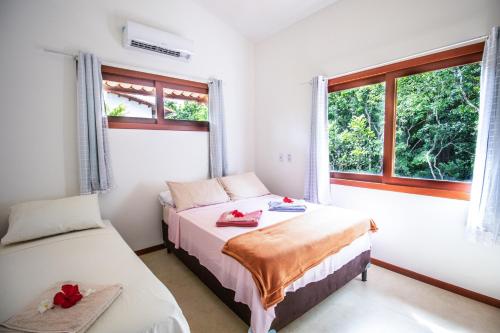 two beds in a room with a window at Lovely Pipa in Pipa