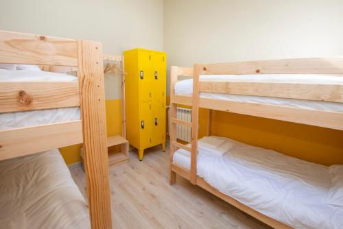 a room with three bunk beds and a yellow cabinet at Palácio dos Marqueses in Mafra