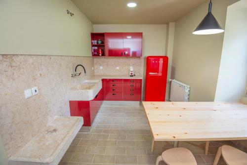 a kitchen with a red refrigerator and a wooden table at Palácio dos Marqueses in Mafra