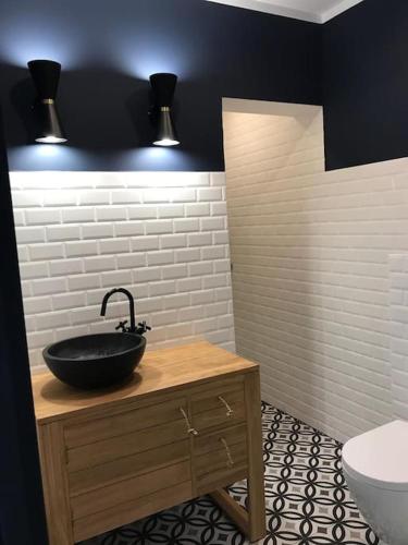 une salle de bain avec un lavabo noir et des toilettes dans l'établissement Beautifully designed homely calm parisian duplex, à Paris