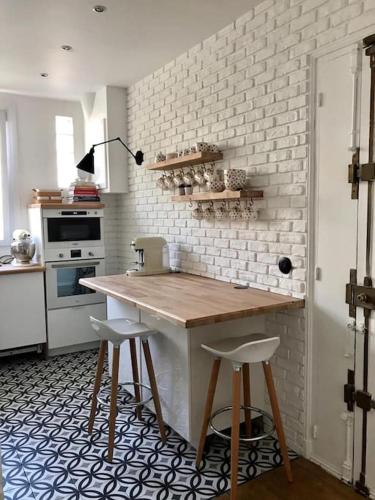 - une cuisine avec un comptoir et deux tabourets dans l'établissement Beautifully designed homely calm parisian duplex, à Paris