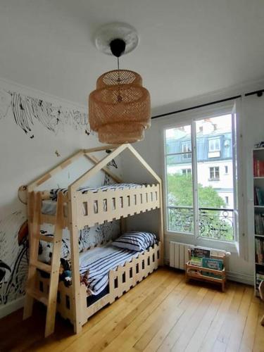 une chambre avec deux lits superposés et une fenêtre dans l'établissement Beautifully designed homely calm parisian duplex, à Paris