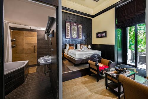 a bathroom with a tub and a bedroom with a bed at Andrassy Thai Hotel in Budapest