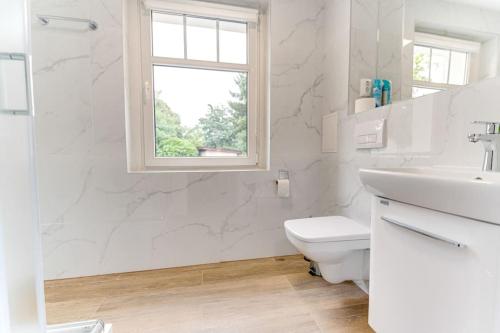 a white bathroom with a sink and a toilet at 2A Neu renoviert 3 Zi Whg 5 Betten 43,41qm in Schwedt