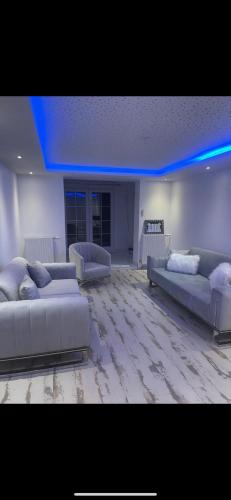 - un salon avec deux canapés et un plafond bleu dans l'établissement Appartement f3 Sevran, à Sevran