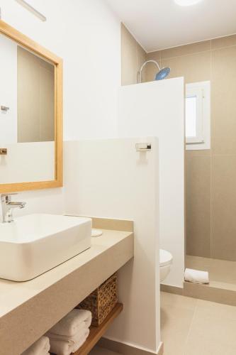a white bathroom with a sink and a mirror at La Floristería Zahora in Zahora