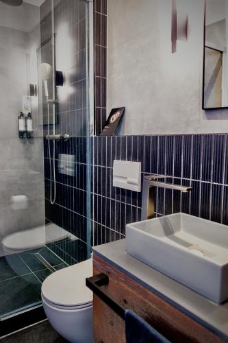 a bathroom with a sink and a toilet and a shower at Lujza B studio 44 in Budapest
