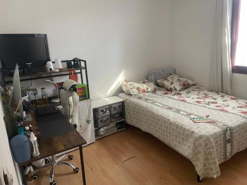 une petite chambre avec un lit et un bureau dans l'établissement Vivien, à Épinay-sur-Seine