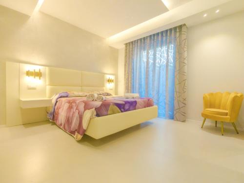 a bedroom with a large bed and a chair at Residence AleDen in Vieste