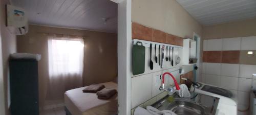 a small bathroom with a sink and a bed at Casa temporada Araçoiaba in Araçoiaba