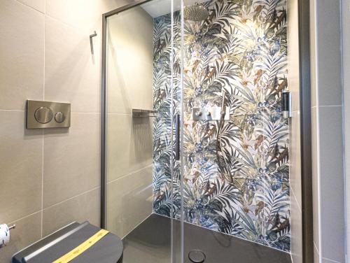 a bathroom with a shower with a blue and white wallpaper at Residence AleDen in Vieste
