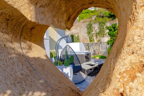 a view through a stone archway into a patio with a chair at Residence AleDen in Vieste