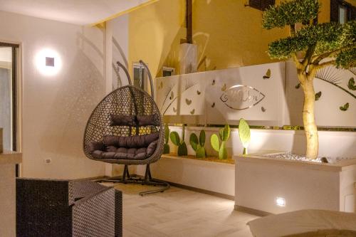 a room with a chair and a tree in it at Residence AleDen in Vieste