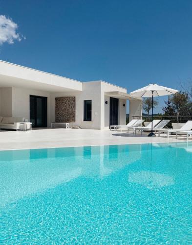 une grande piscine devant une maison dans l'établissement Villa Fontvieille, à Zonza