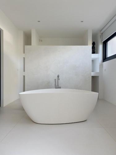 La salle de bains blanche est pourvue d'une baignoire blanche et d'un lavabo. dans l'établissement Villa Fontvieille, à Zonza