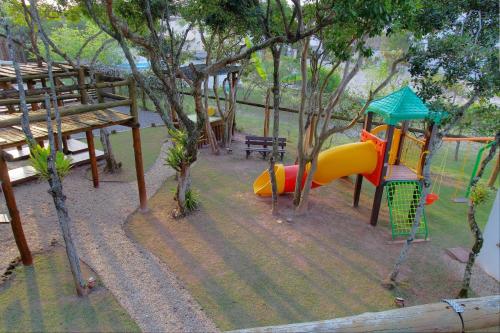 a playground with a slide in a park at Pousada Arágua in Bombinhas