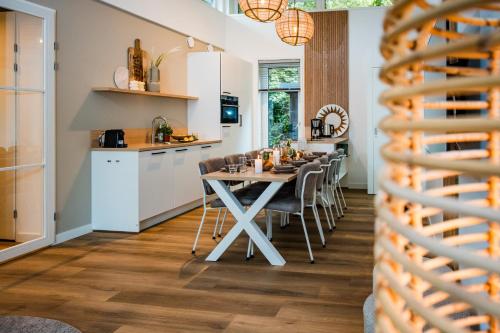 a kitchen and dining room with a table and chairs at Recreatiewoning 'Steenpatrijs' op Gemoedelijk Vakantiepark in Voorthuizen