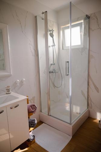 a bathroom with a shower with a glass door at Apartmani Natalija 4 Stars in Mrljane