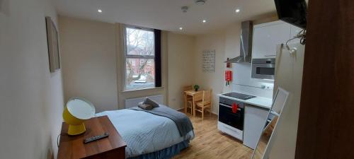 Un pequeño dormitorio con una cama y una cocina. en 37chats studio, en Londres