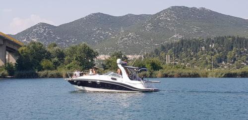a boat on a lake with mountains in the background at Kuća za odmor Nera in Komin