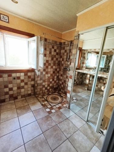 La salle de bains est pourvue d'une douche et de carrelage. dans l'établissement Maison de campagne, à Lançon-Provence